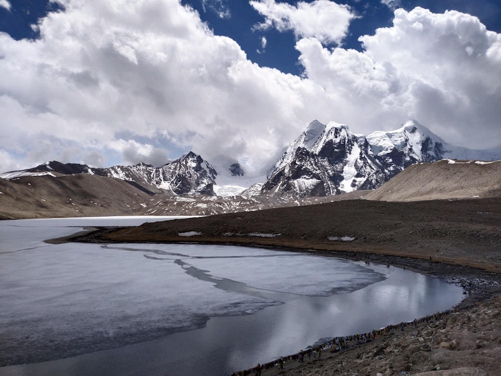 a lake with snowy mountains in the background