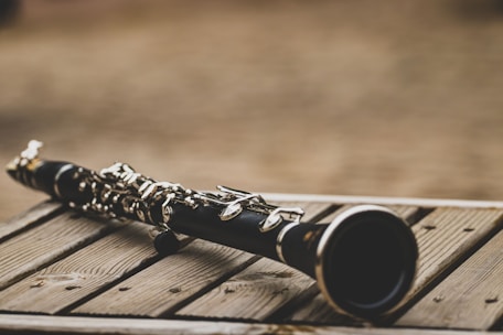 Close-up of clarinet keys on a wooden table.