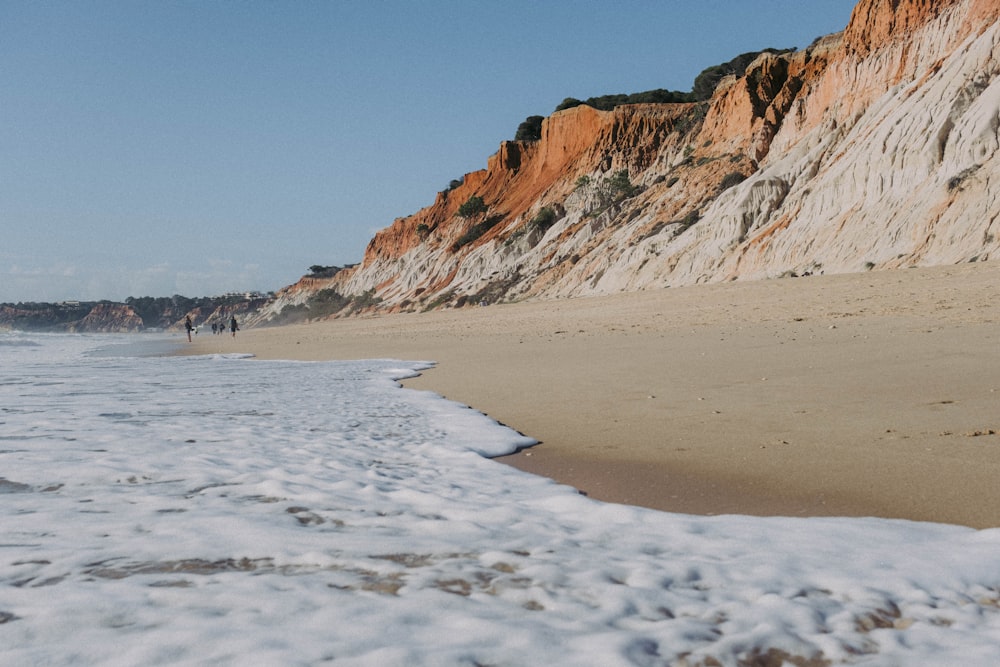 a beach with a rocky cliff