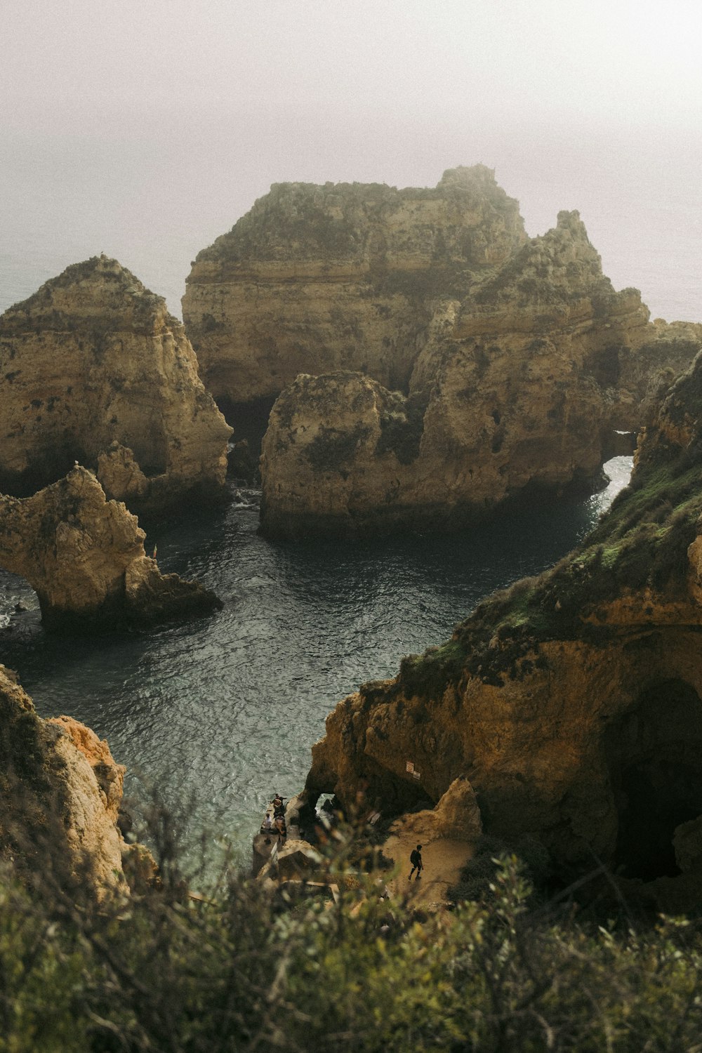 a rocky cliff with a body of water below