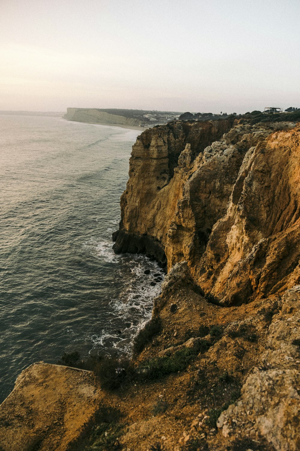 a cliff with a body of water below