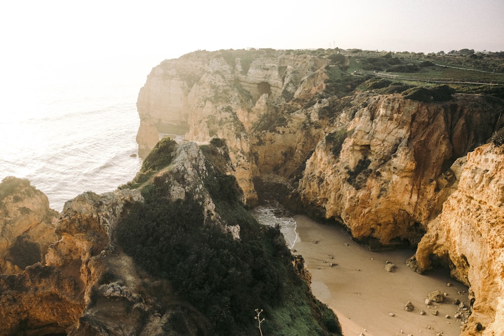 a rocky cliff next to a beach