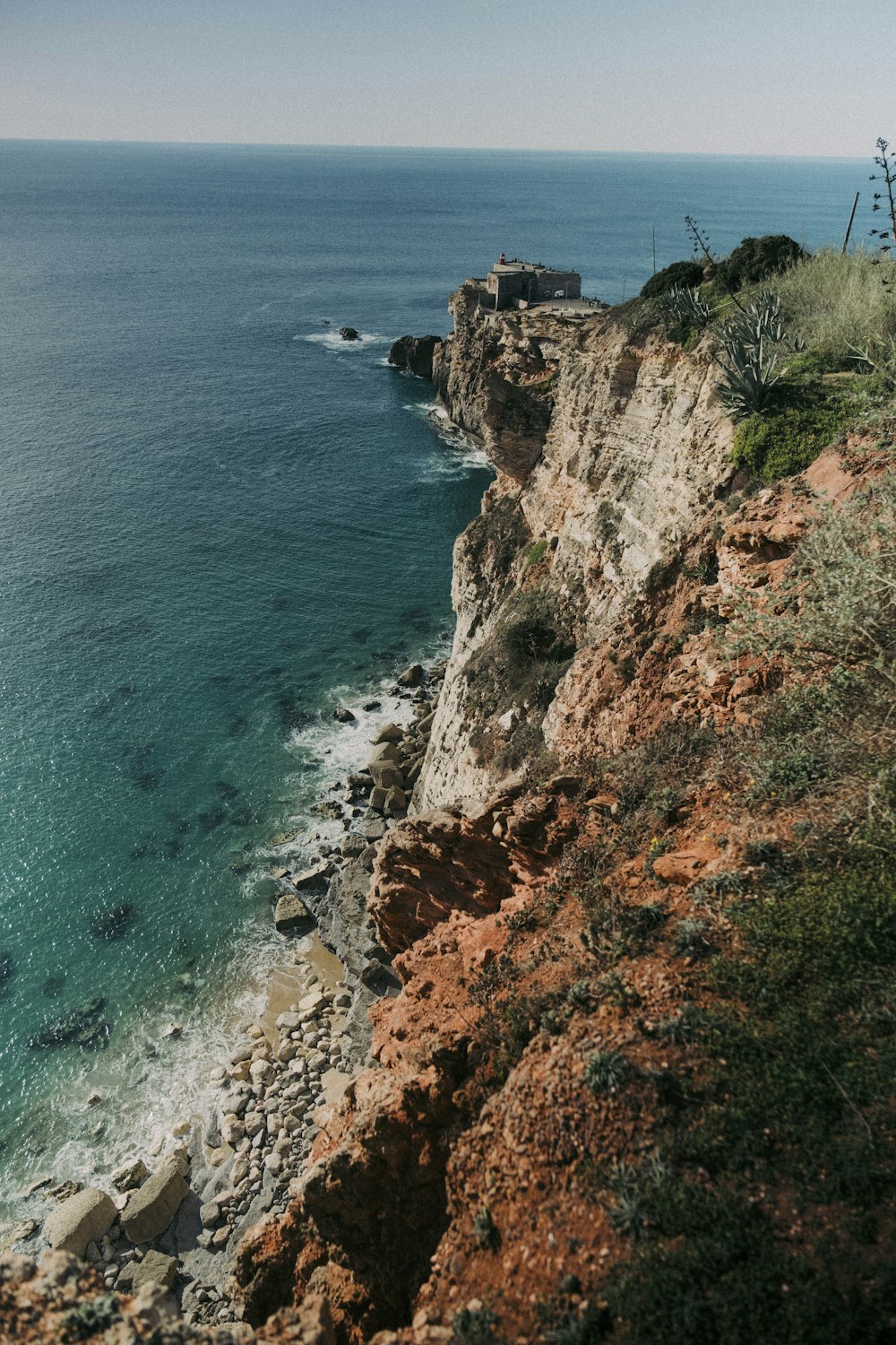 a rocky cliff next to a body of water