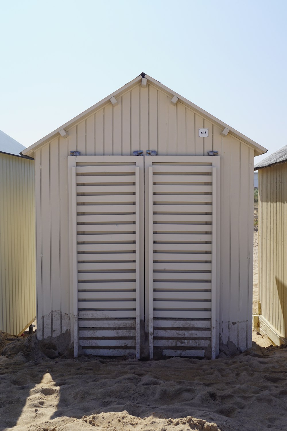 a white shed with a metal door