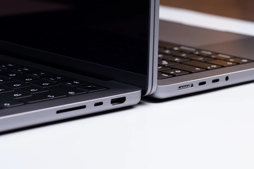 A sleek display of the latest Dell XPS and HP Spectre laptops glowing under showroom lights.