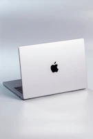 a silver laptop with a black apple logo on the screen