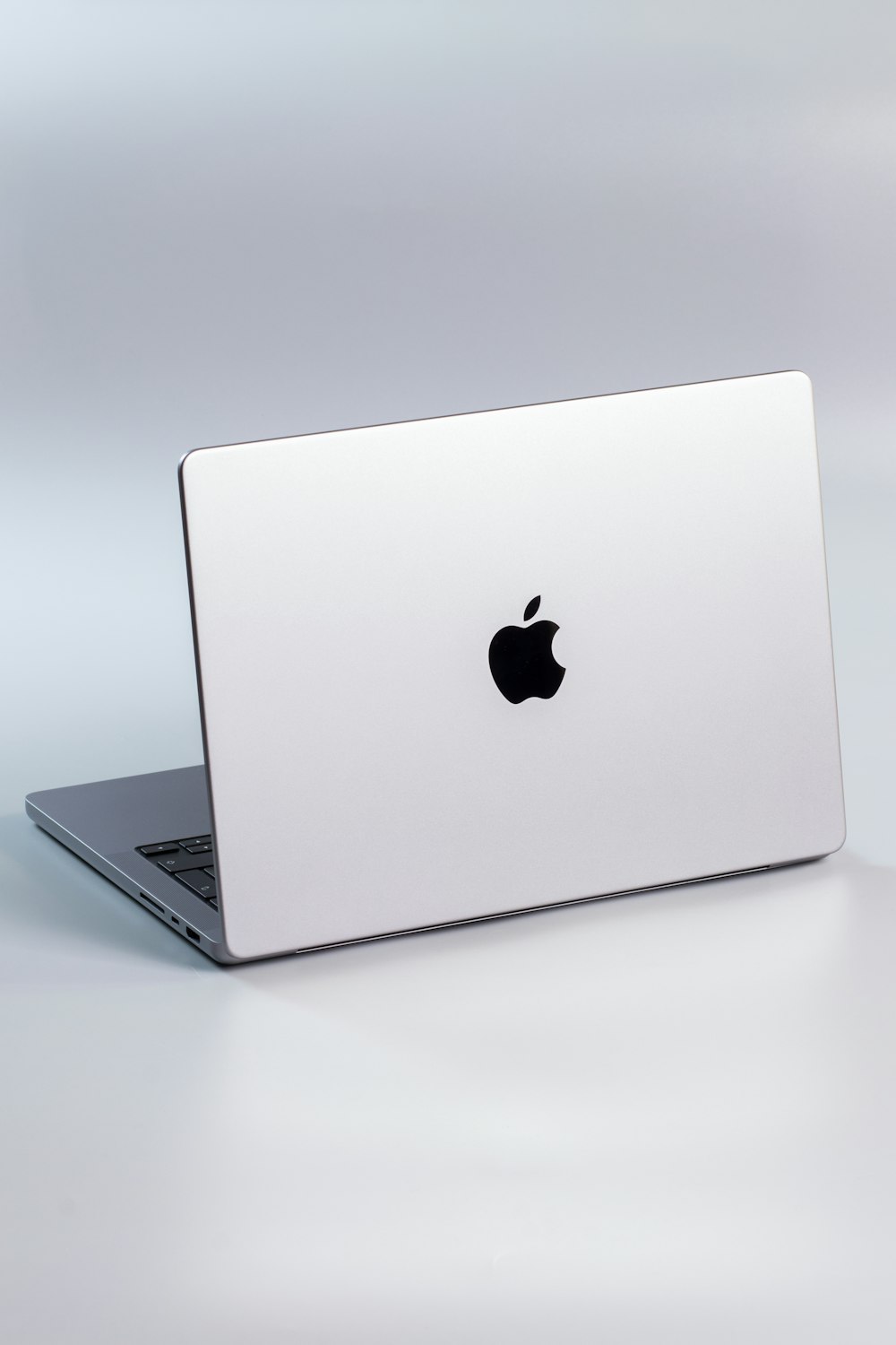 a silver laptop with a black apple logo on the screen