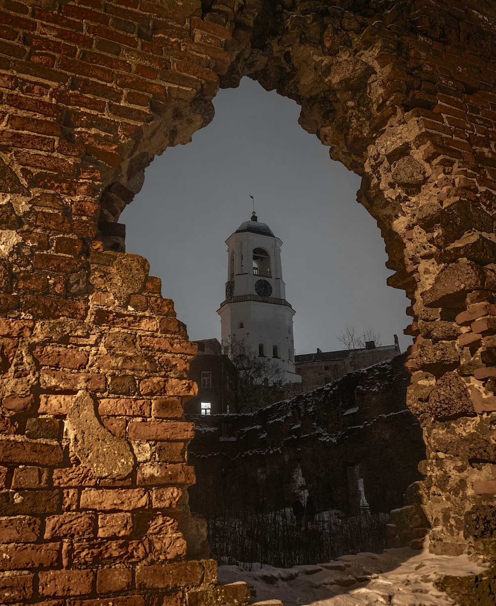 a stone archway with a building in the distance