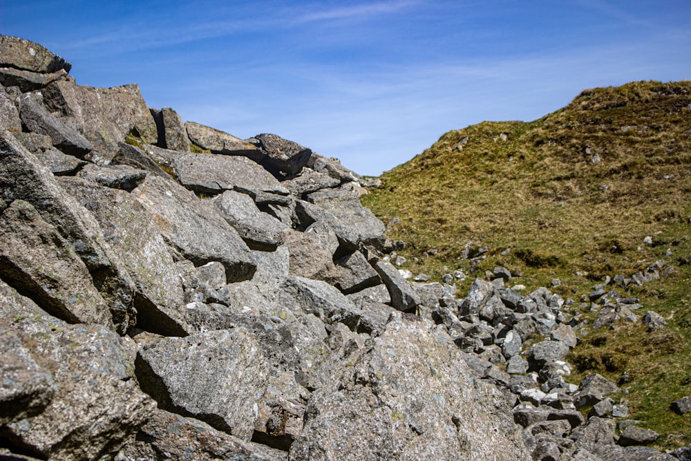 a rocky hillside with grass and rocks