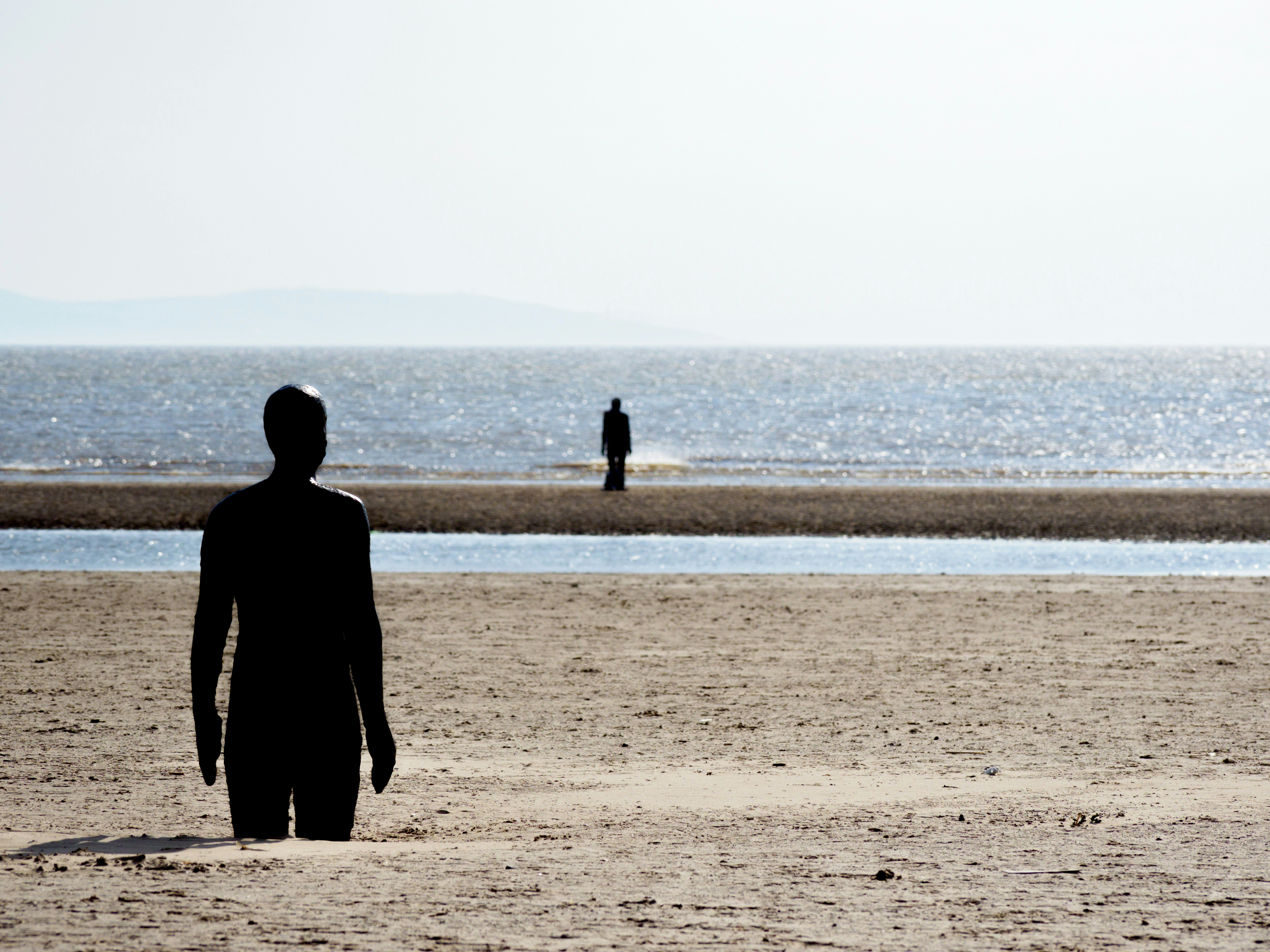 a couple of people walking on a beach