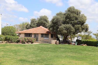 A cozy family home surrounded by a lush garden on a sunny day.