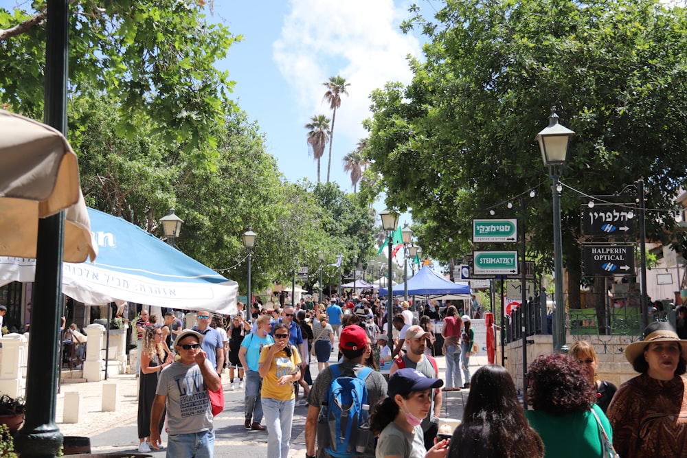 a crowd of people walking on a sidewalk