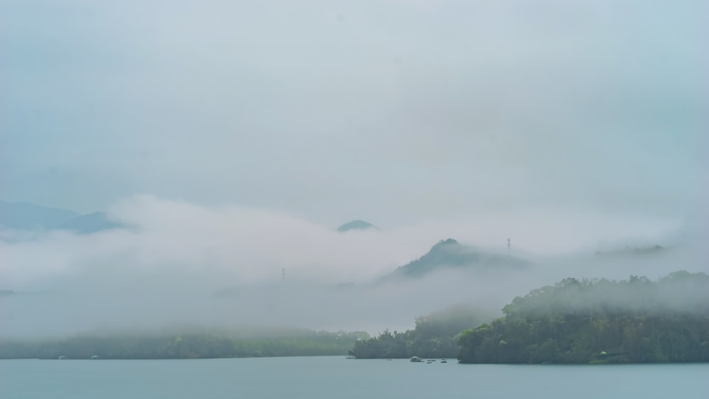 a body of water with trees and mountains in the background