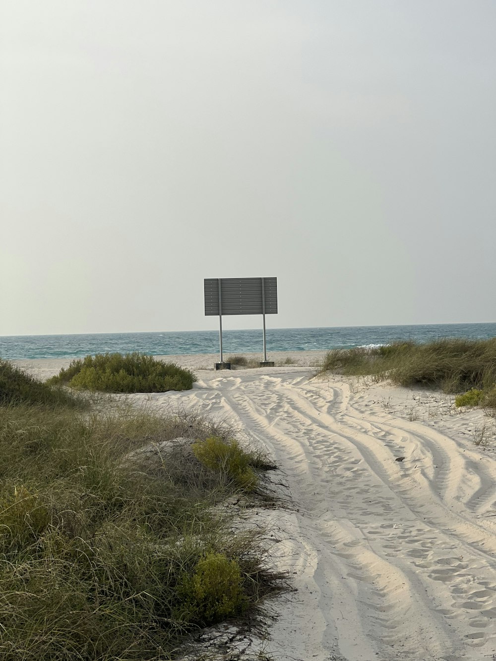 a sandy beach with a sign