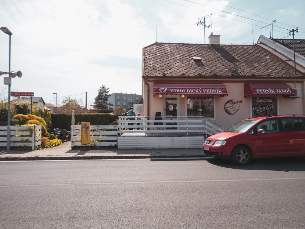 a red car parked in front of a building