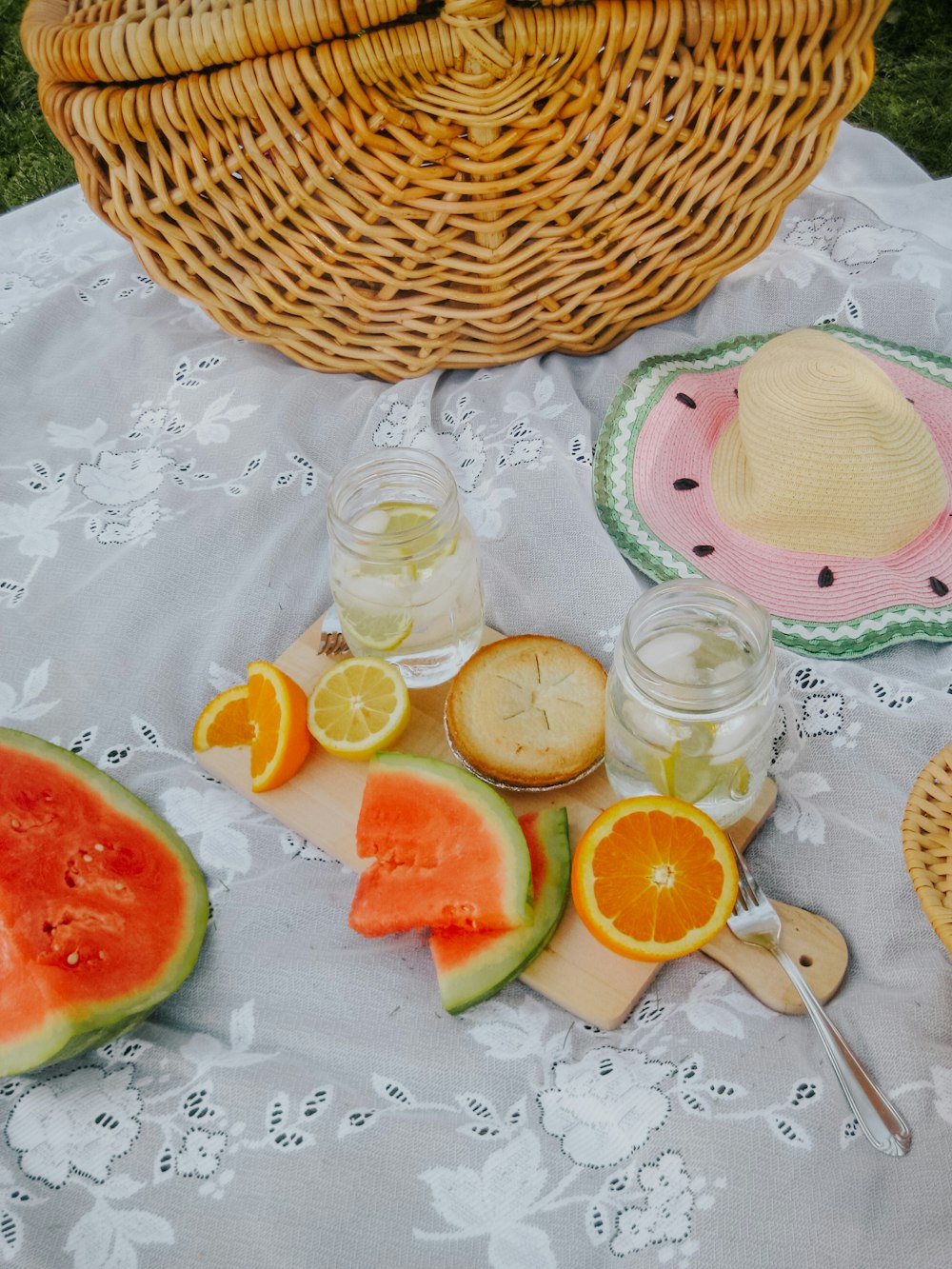 a basket of fruit and a glass of juice on a table