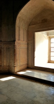 Architect examining a room with natural and artificial light interplay highlighting architectural details.