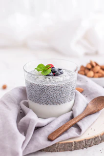 A vibrant plate with chia pudding topped with kiwi slices, coconut flakes, and a drizzle of natural syrup.