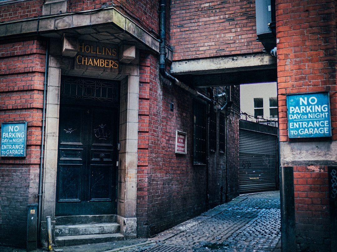 a brick building with a sign on it, A back alley in Manchester with a strong retro look.