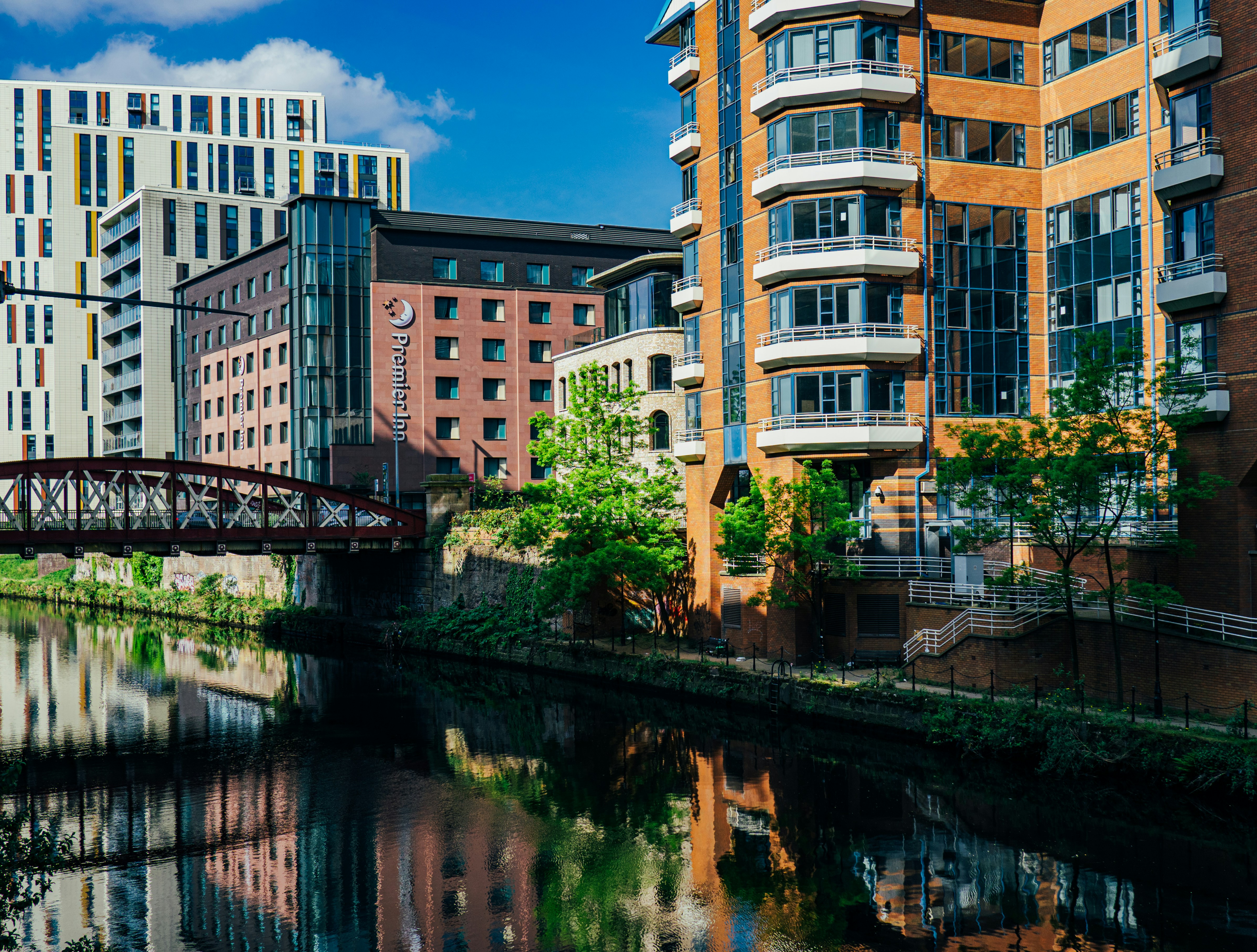 Buildings from Salford reflect on the canal, as seen from Manchester.