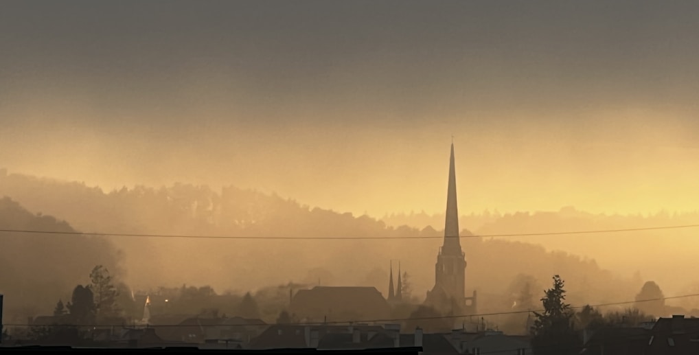 A serene landscape with a sunrise over a peaceful church.