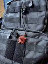 Close-up of rugged tactical plate carrier and modular pack on display.