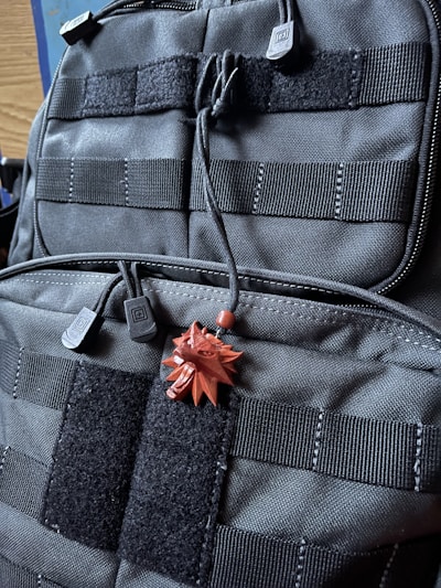 Close-up of a heavy-duty canvas backpack with patriotic patches and rugged stitching.