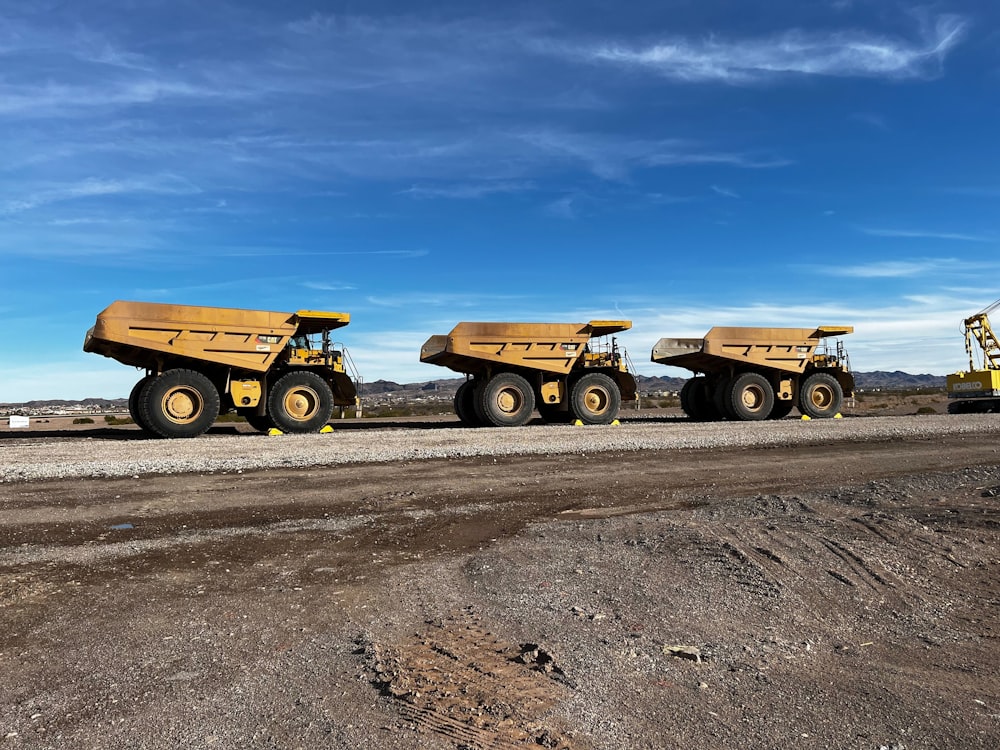 a few yellow trucks on a road