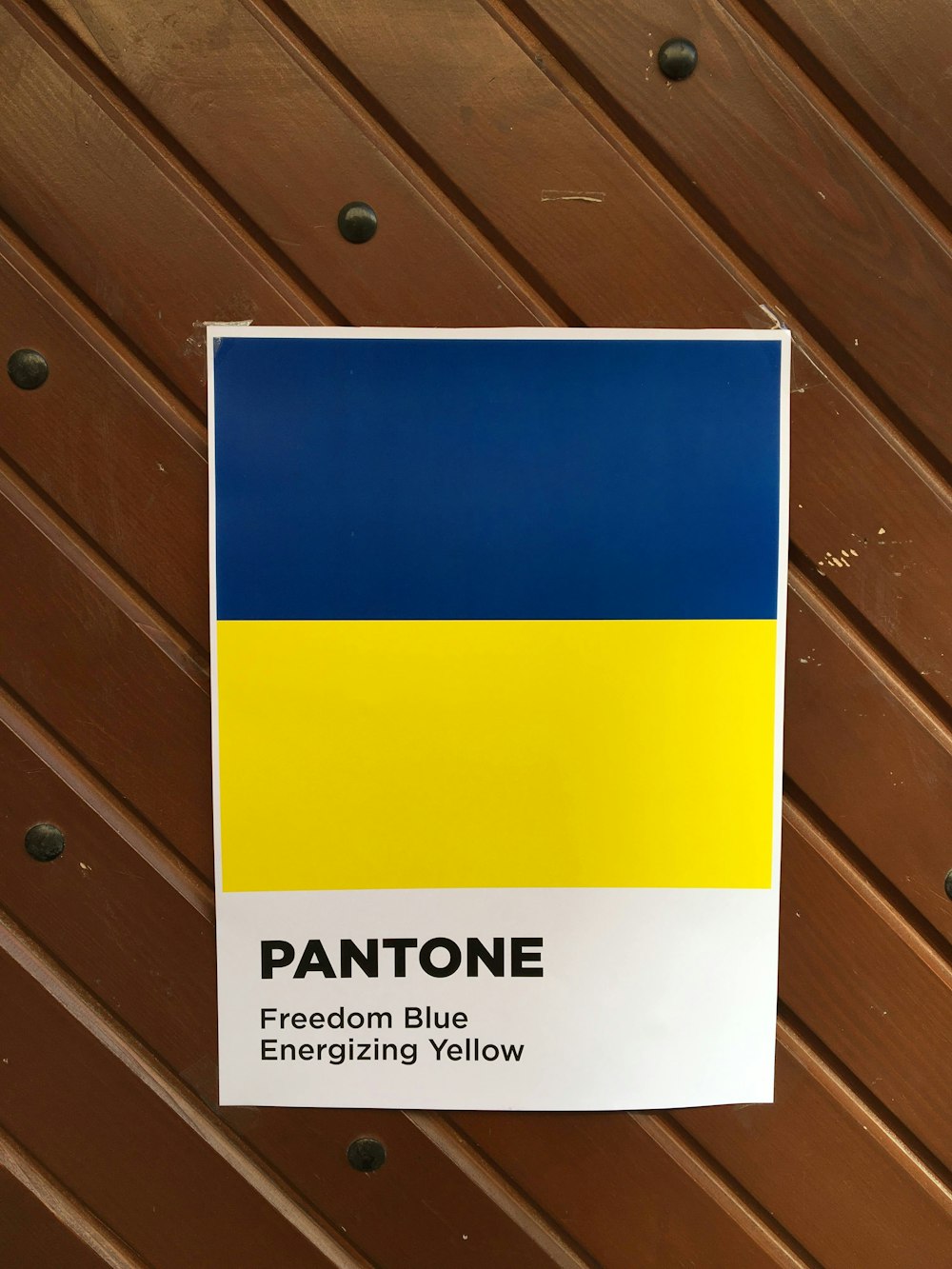 a yellow and blue sign on a wooden surface
