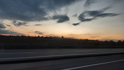 Sunset view over a quiet highway cutting through dense forest in Azad Kashmir.
