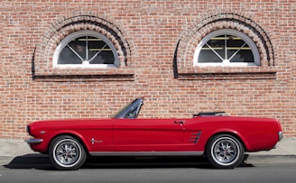 a red car parked in front of a brick building