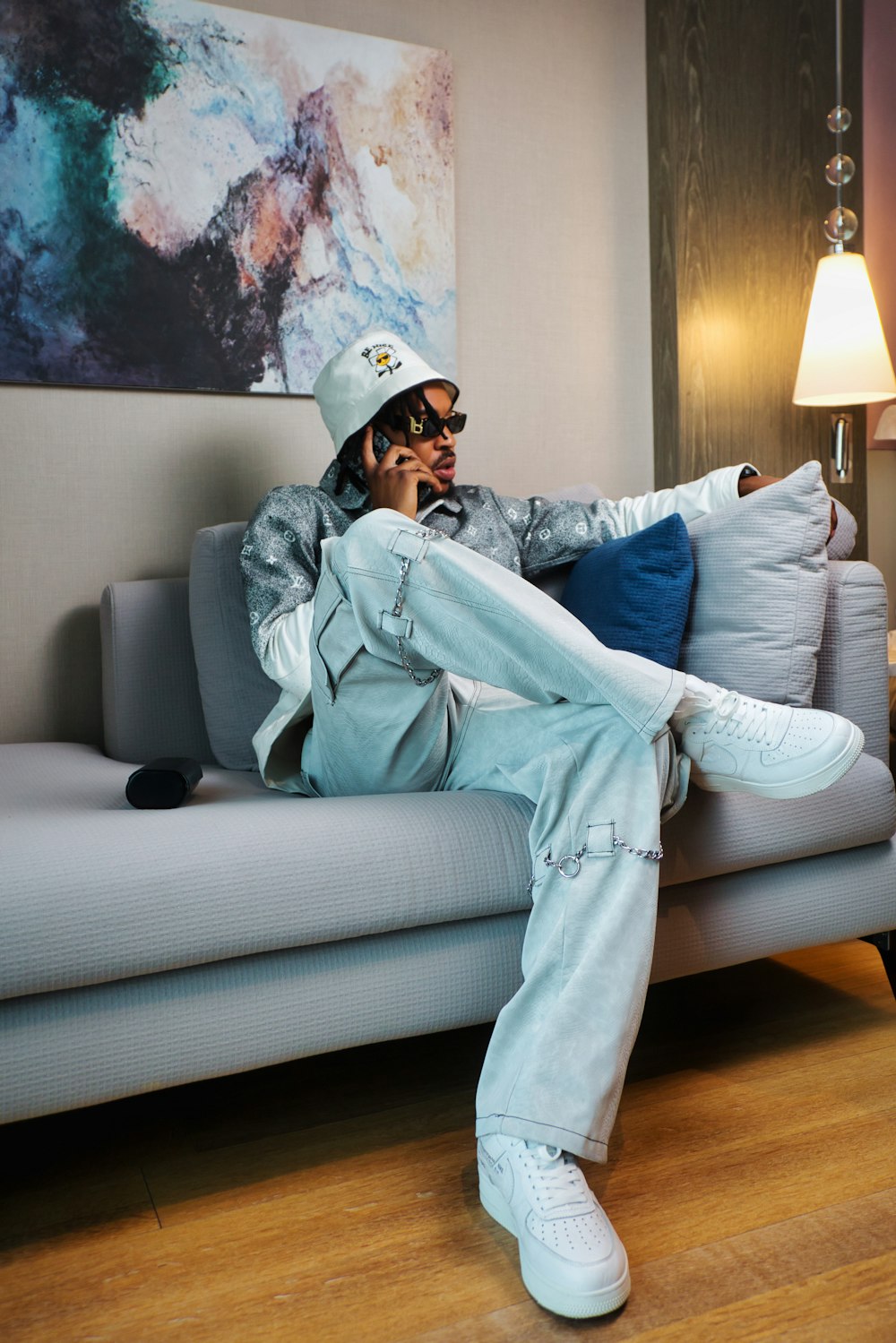 a person in a white helmet and sunglasses sitting on a couch