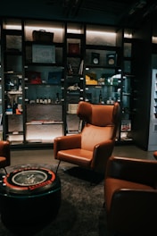 a room with a glass case and chairs