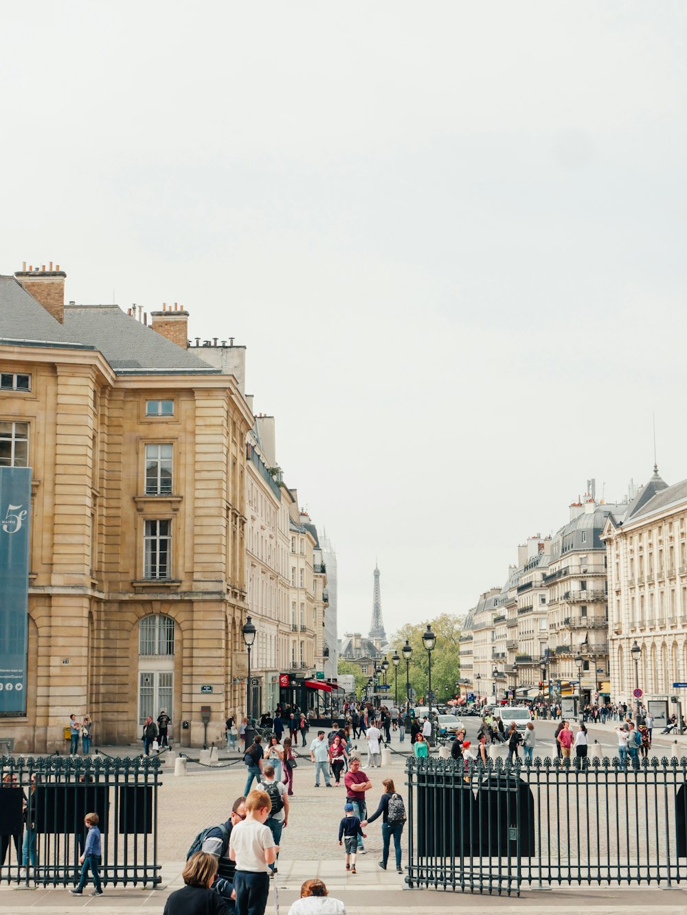 a group of people walking on a street between buildings