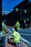 a group of men in yellow jackets standing on a sidewalk