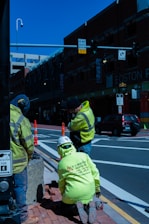 a group of men in yellow jackets standing on a sidewalk
