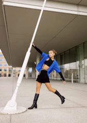 A stylish fashion photoshoot with a model posing in a vibrant urban setting.