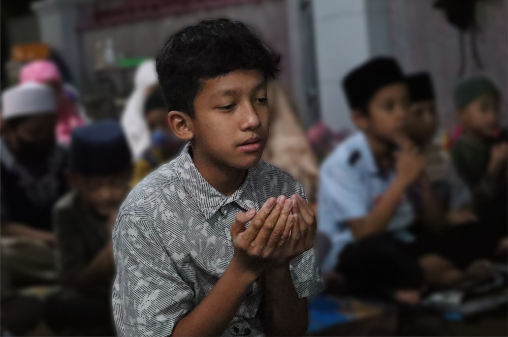 a young boy with his hands together