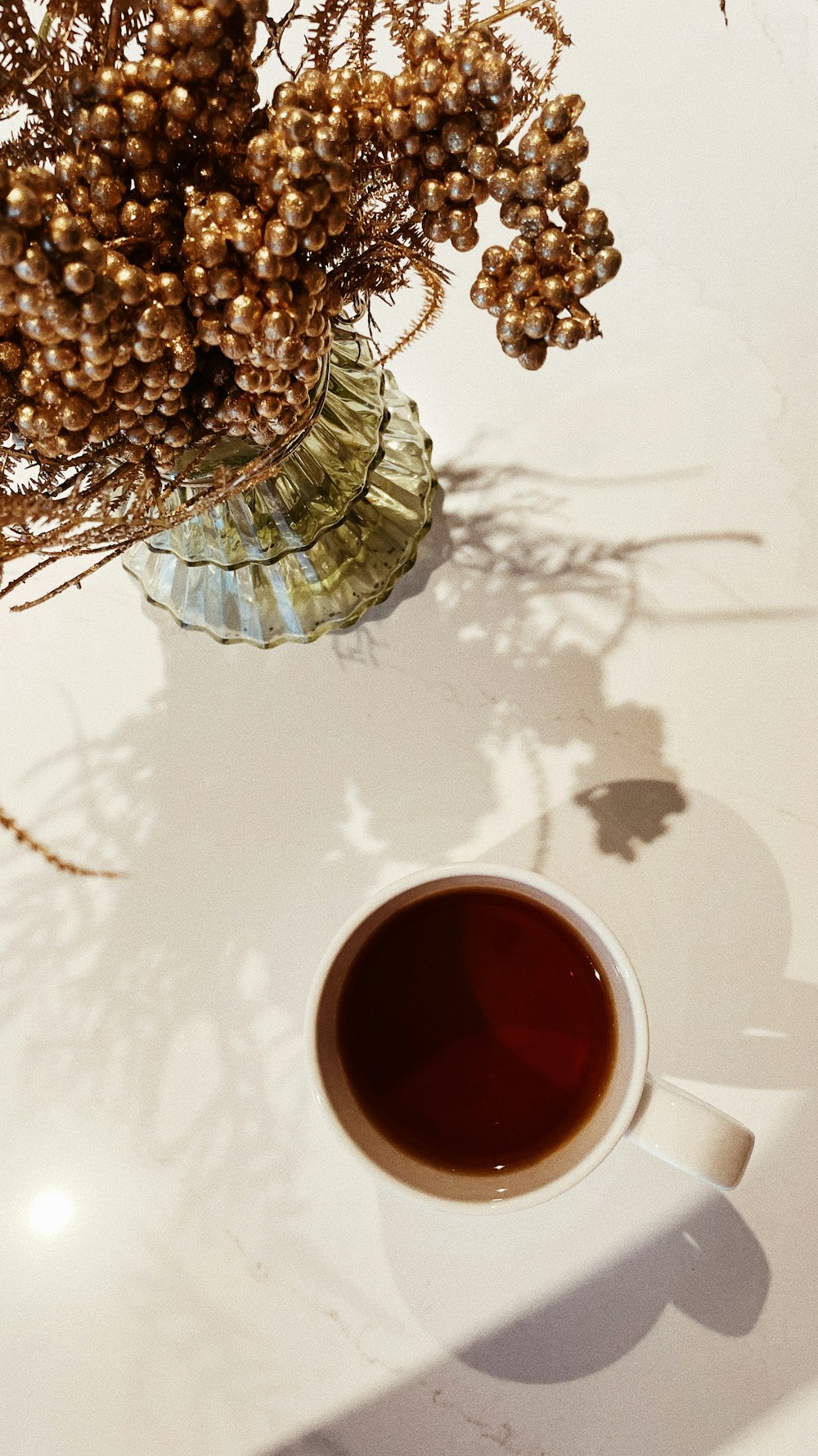 a cup of coffee next to a pineapple on a table