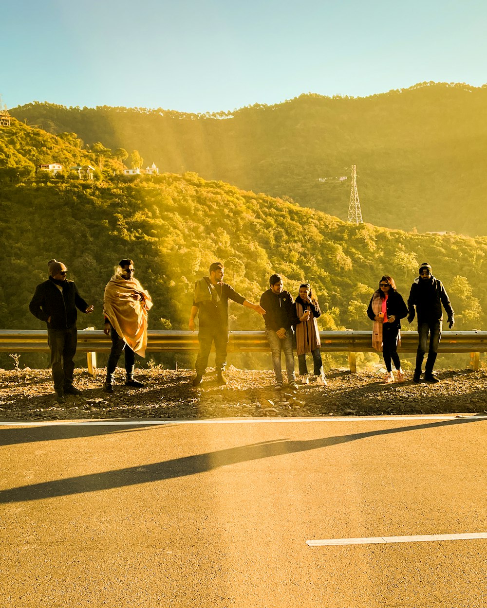 a group of people standing on a road with a mountain in the background