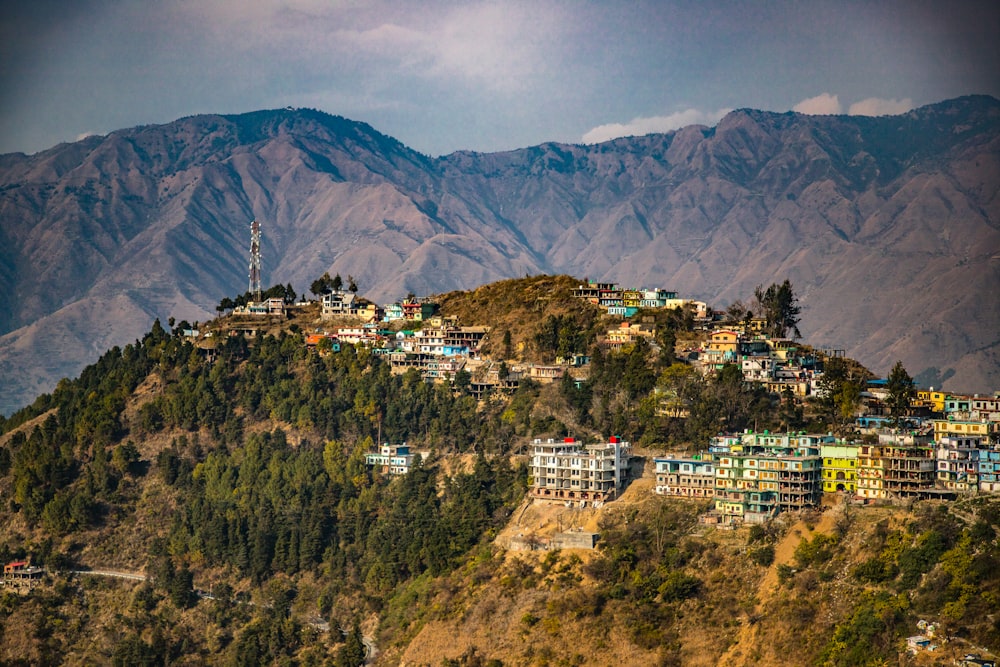 a city on a hill with mountains in the background