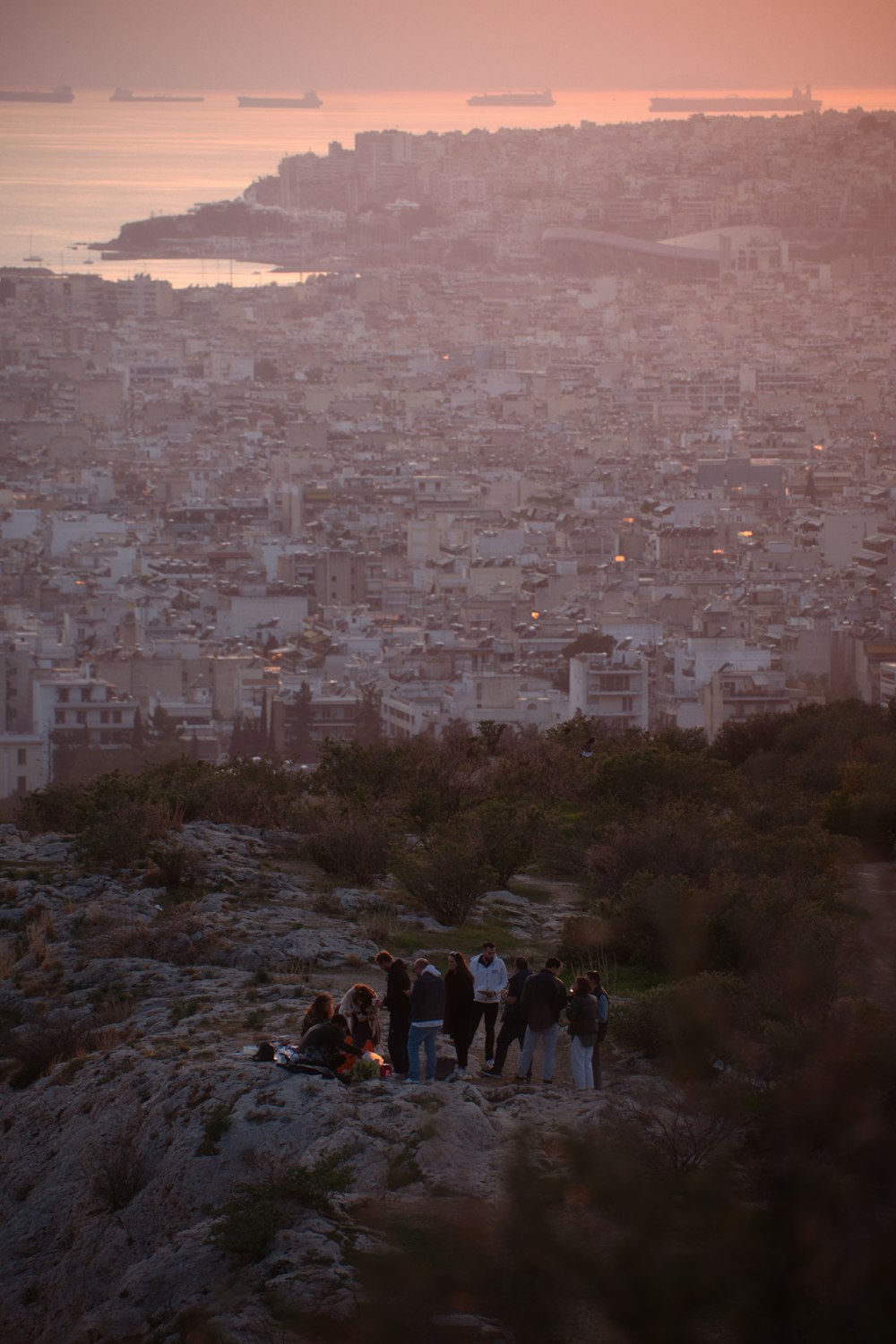 um grupo de pessoas em pé em uma colina com vista para uma cidade