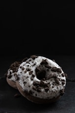 Two Oreo donuts stacked on top of each other on a black background