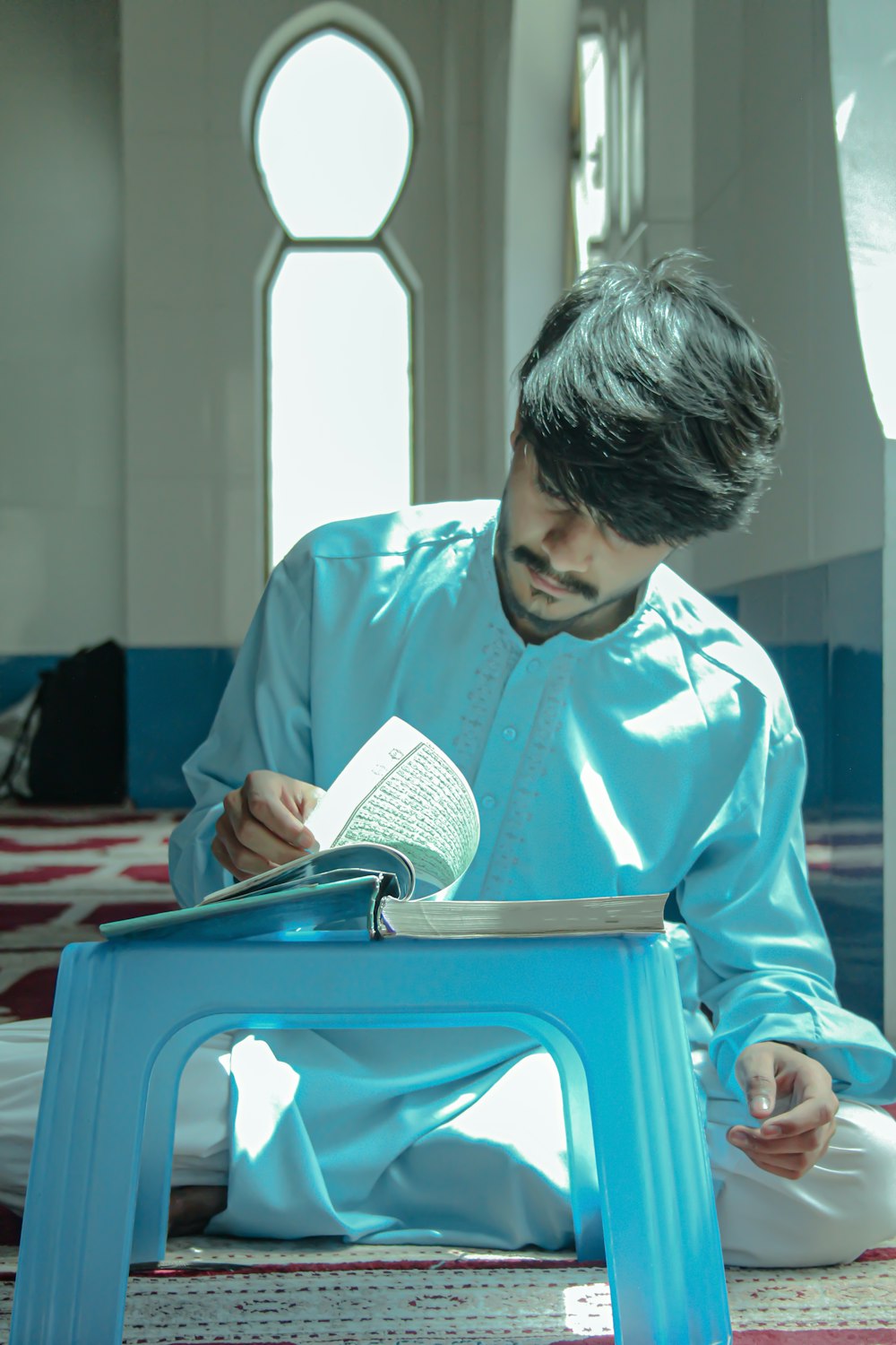 a person sitting on a bench reading a book