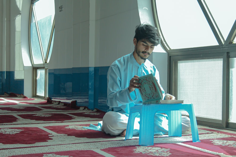 a person sitting on the floor reading a book