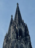 Visitors admiring the towering spires against a clear blue sky.