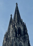 A stunning view of the Duomo di Milano with its intricate gothic spires against a clear blue sky.
