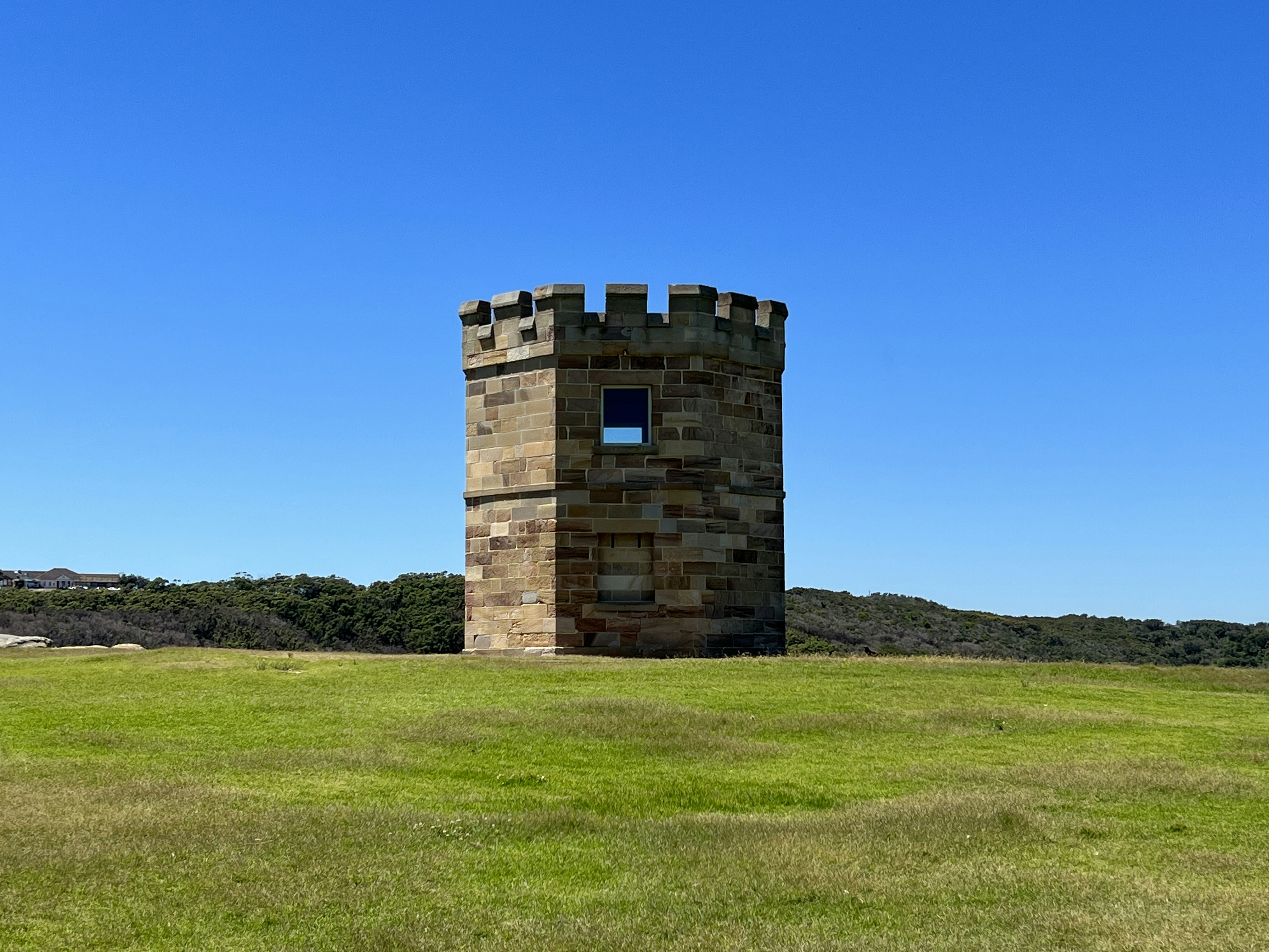 a stone building on a grassy hill