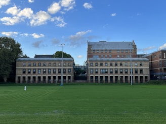 a large building with a green lawn
