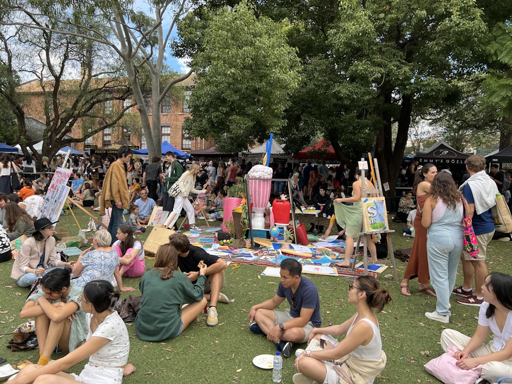 a group of people sitting on the grass